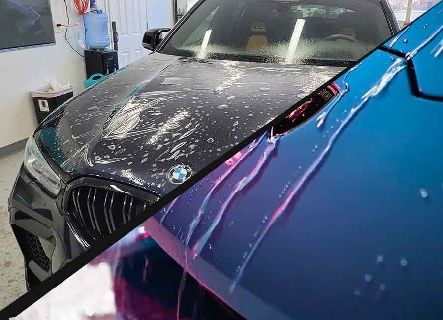 Black BMW under washing, seen beside a blue car with pink soap streaks.