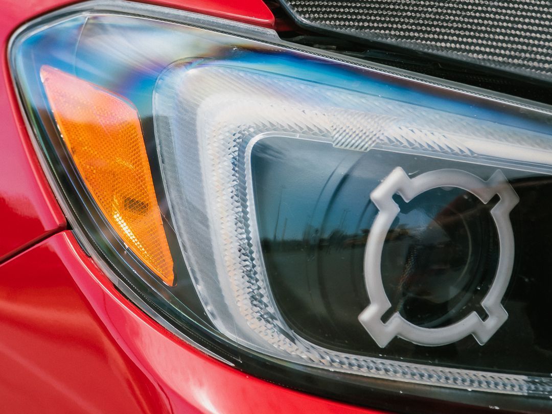 Red car headlight with custom white LED halo and amber turn signal.