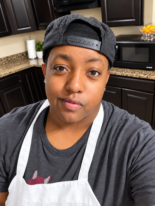 Owner of Queen's Mac N' Cheese wearing an apron in the kitchen