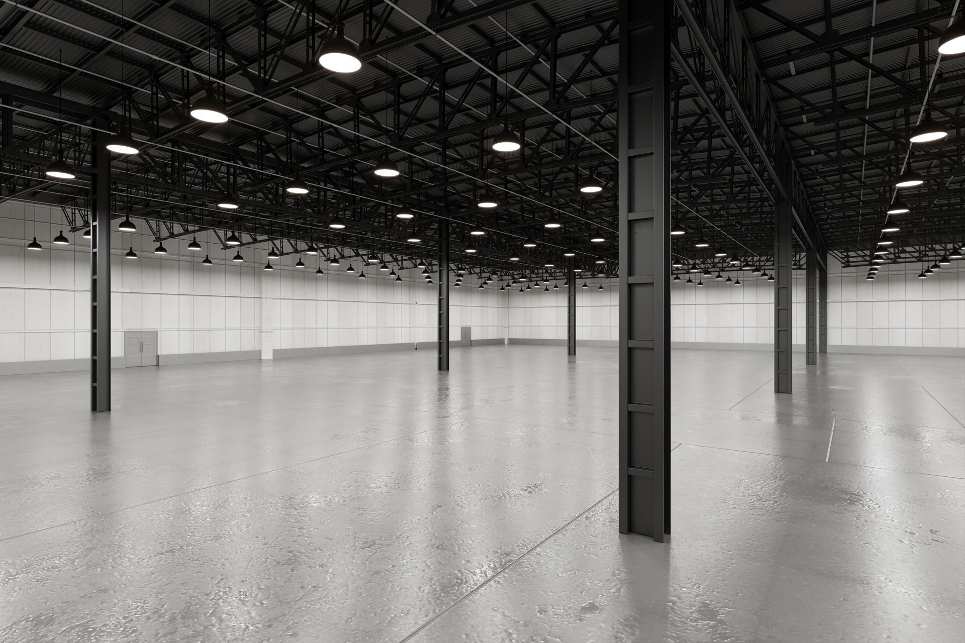 Empty warehouse interior with polished concrete floor, steel columns, and high dark ceiling lights