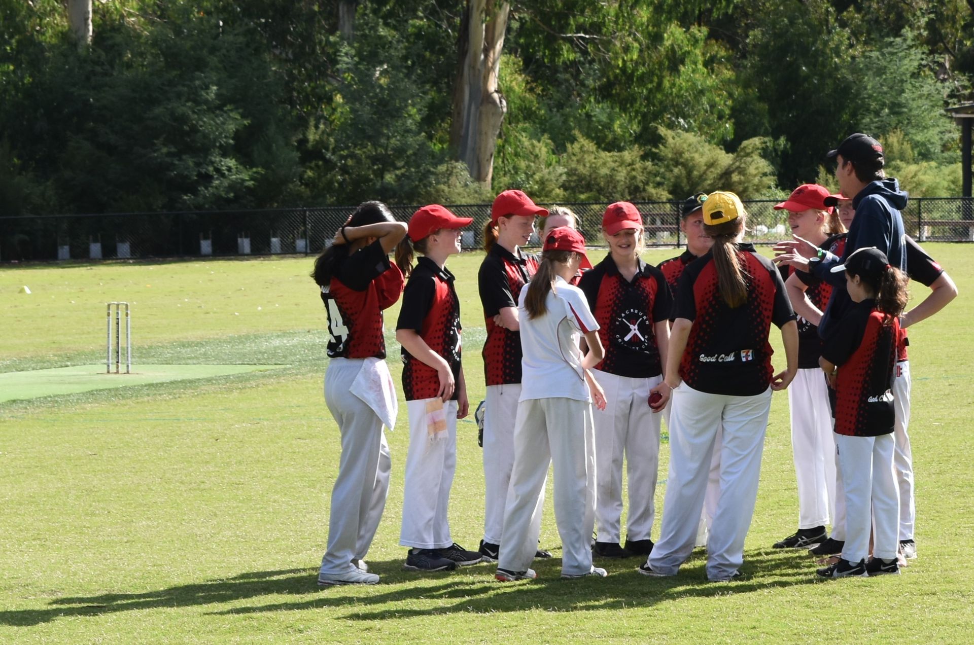 Junior girls team speaking to coach Luke Gibson.