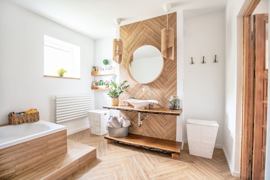 A bathroom with a sink , mirror and bathtub.