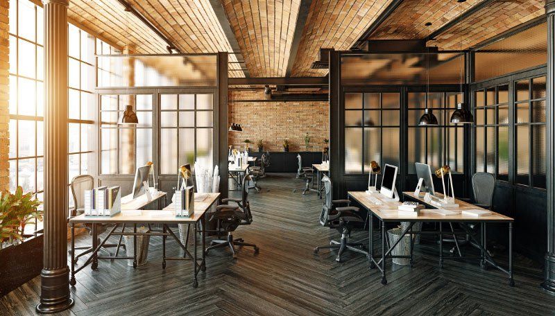 An empty office with lots of windows and tables and chairs.