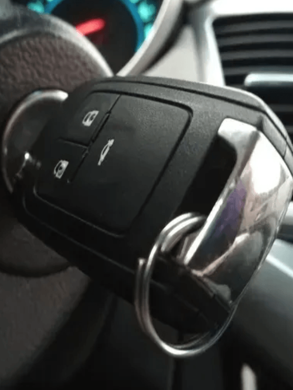 A close up of a car key on a steering wheel