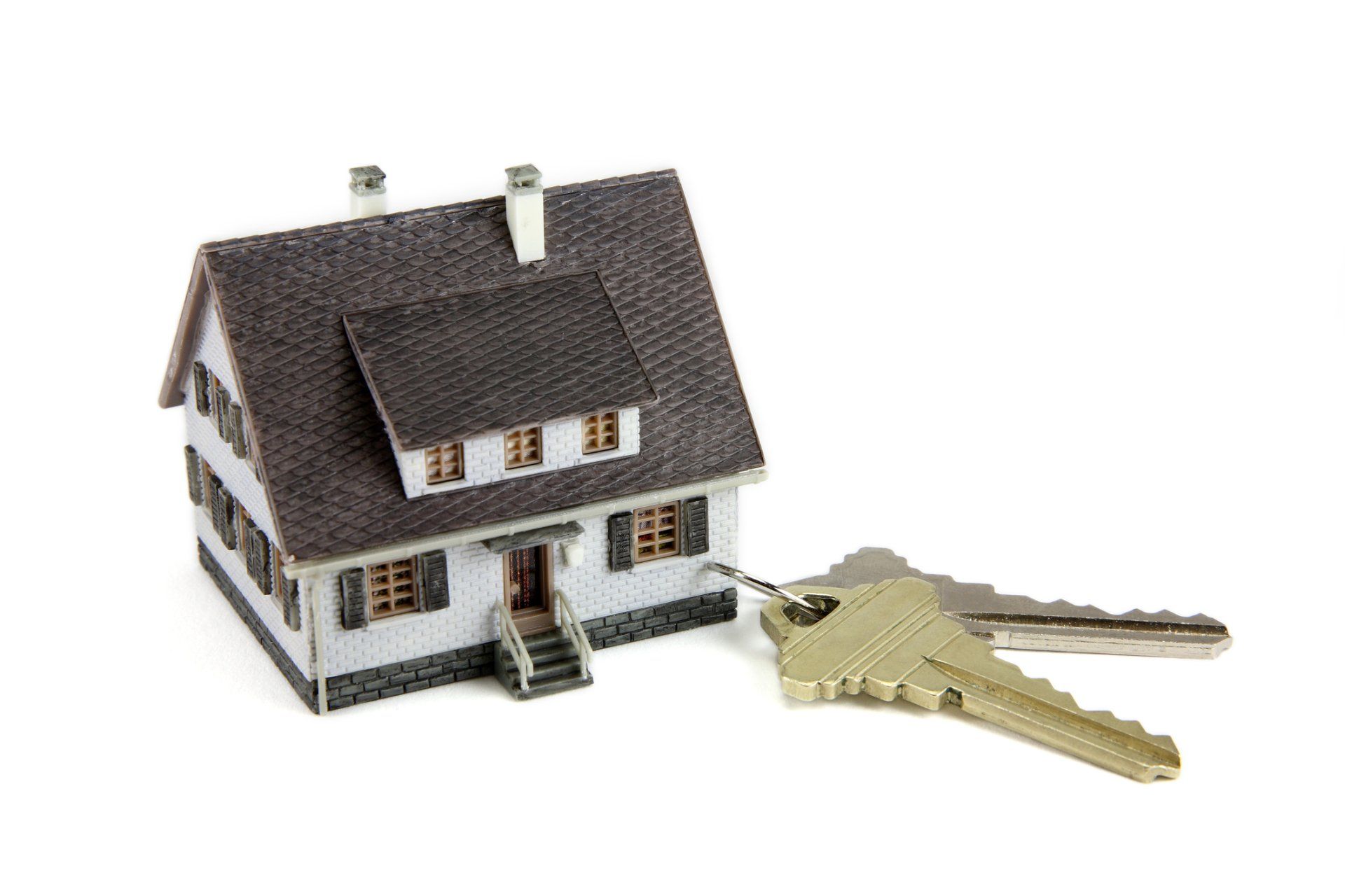 A model house with two keys attached to it.