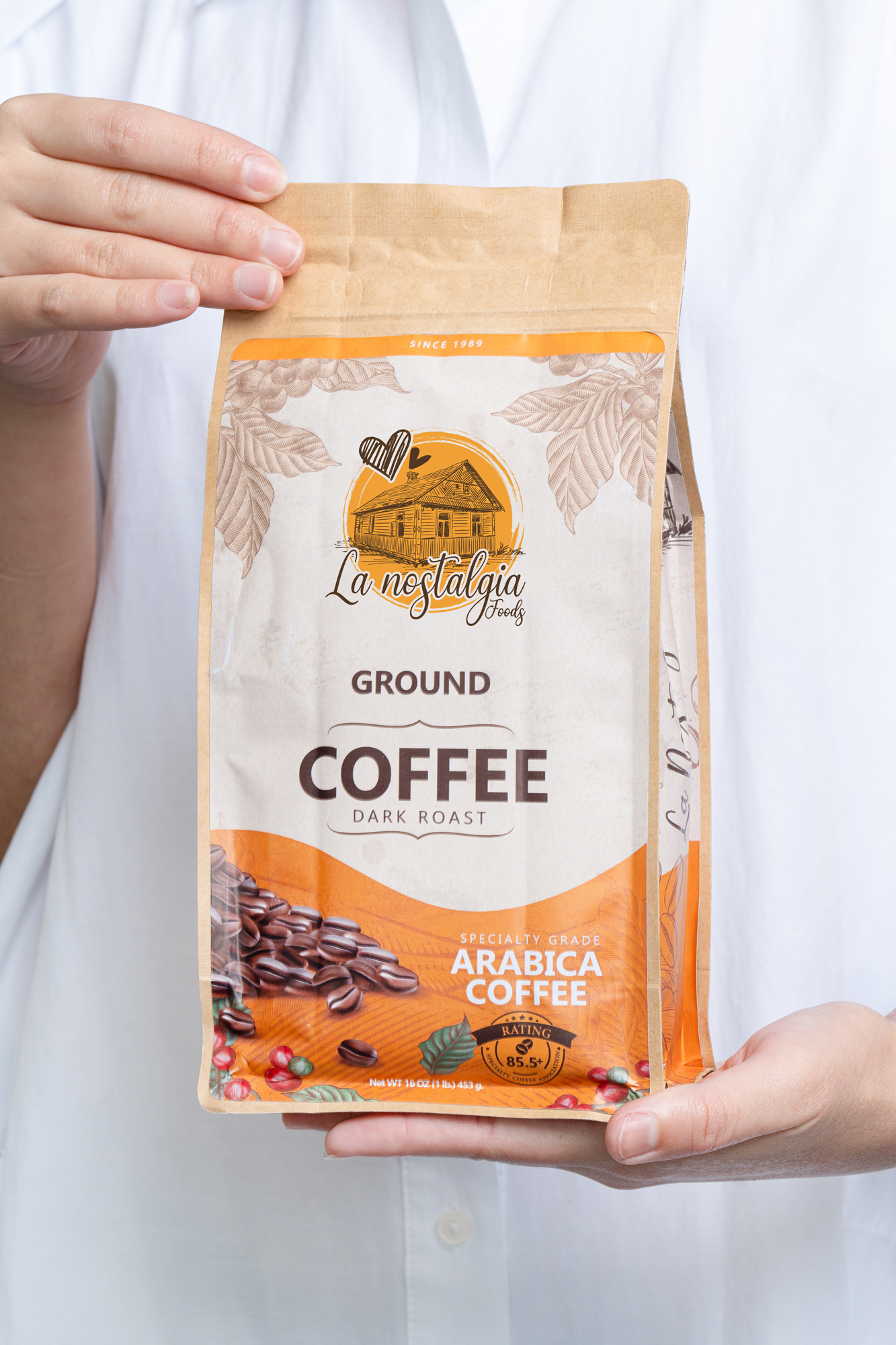 A person is holding a bag of ground coffee in their hands.