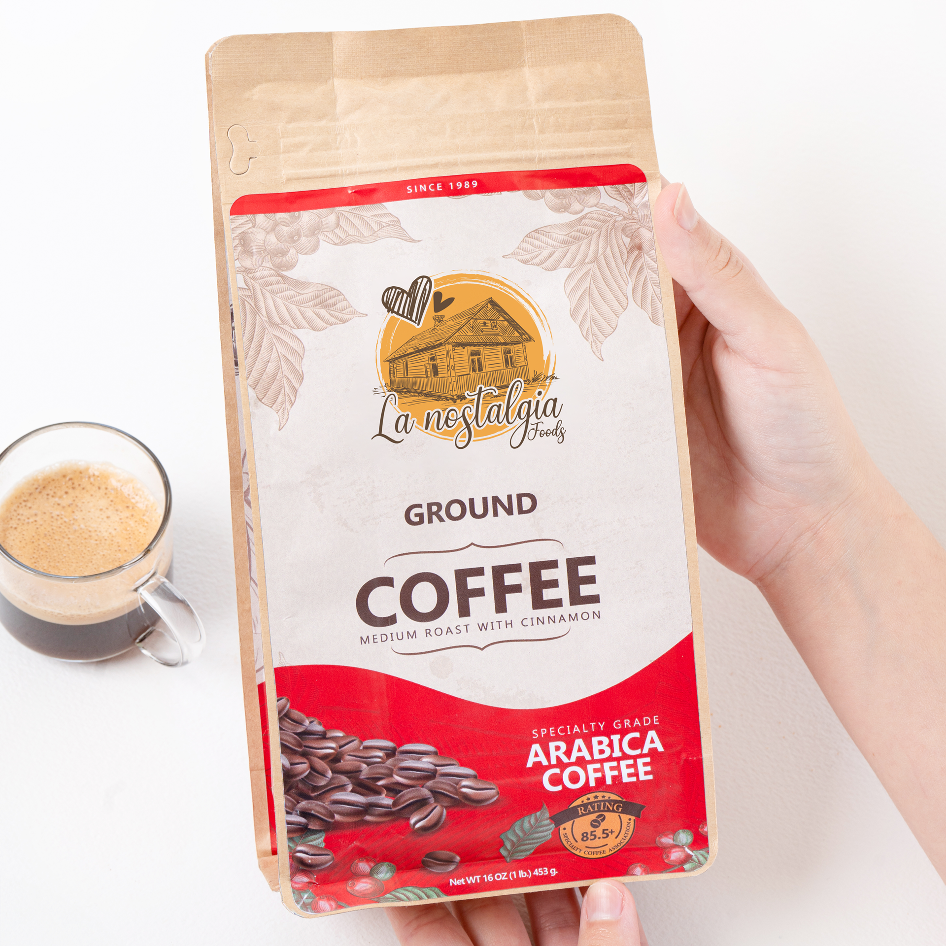 A person is holding a bag of ground coffee