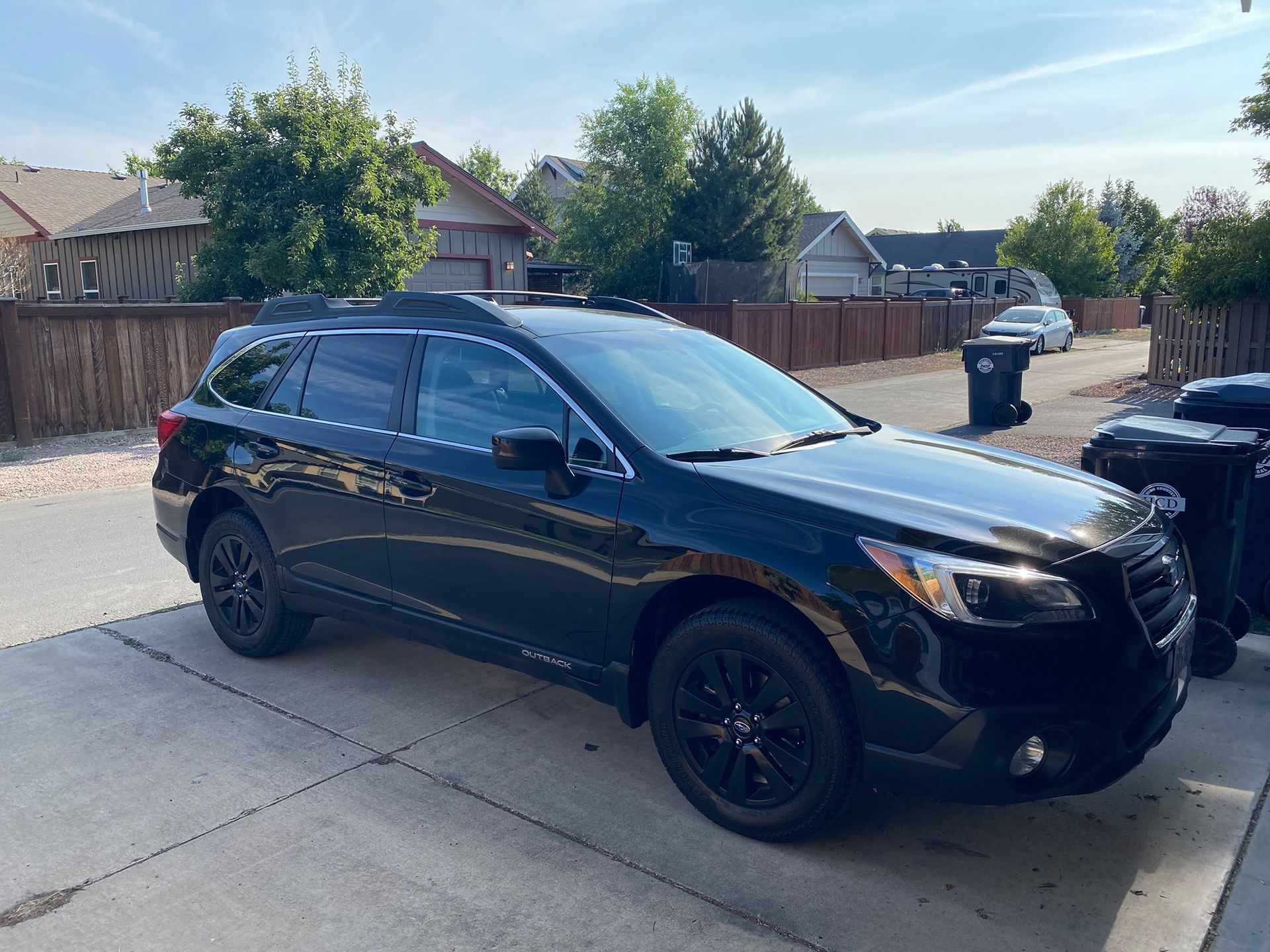 Black SUV parked in a residential driveway on a sunny day
