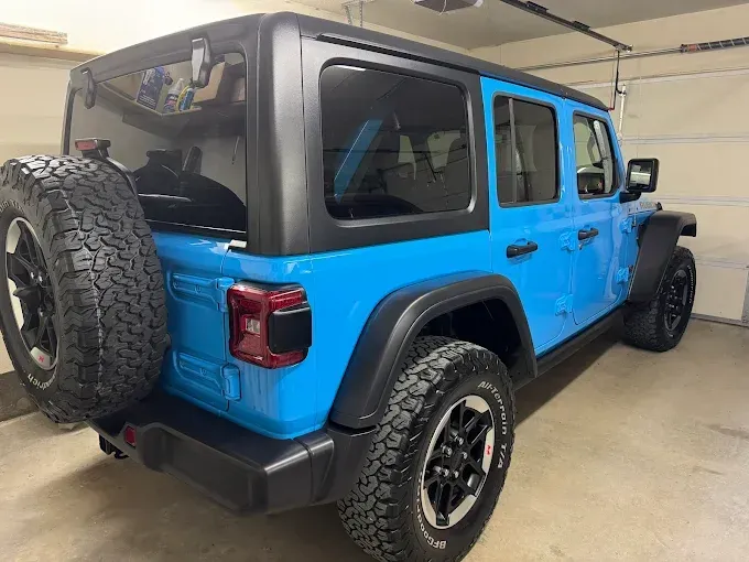Blue Jeep Wrangler with darkened window tint for privacy and UV protection