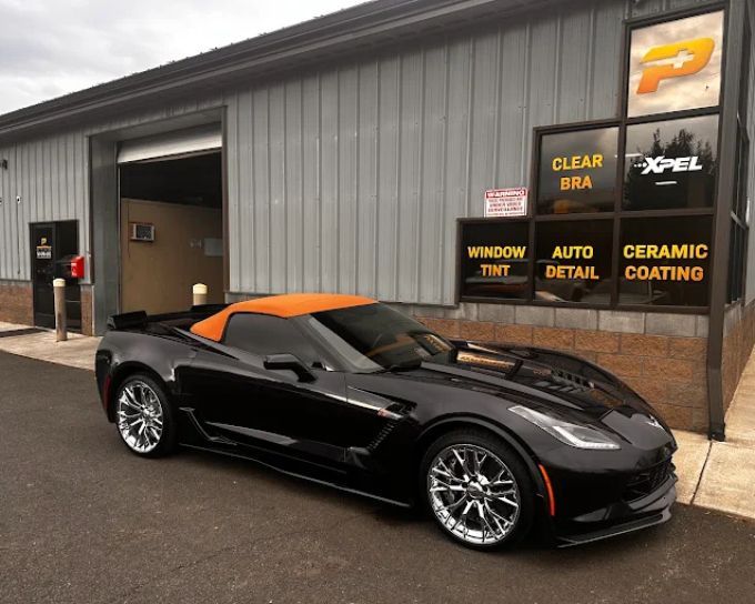 Black Chevrolet Corvette with ceramic coating parked at Perfection Plus Auto Salon, featuring window tint and PPF services
