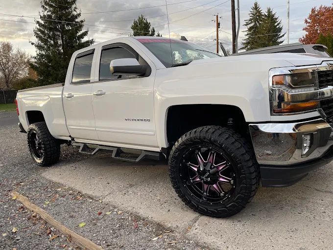 White lifted Chevrolet Silverado truck with darkened window tinting in Redmond, OR