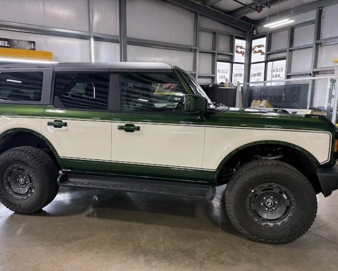 Green and white Ford Bronco with tint darkness applied to windows, detailed in-shop