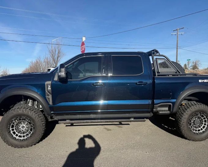 Blue Ford Shelby truck with tinted windows, side profile in Redmond, Oregon
