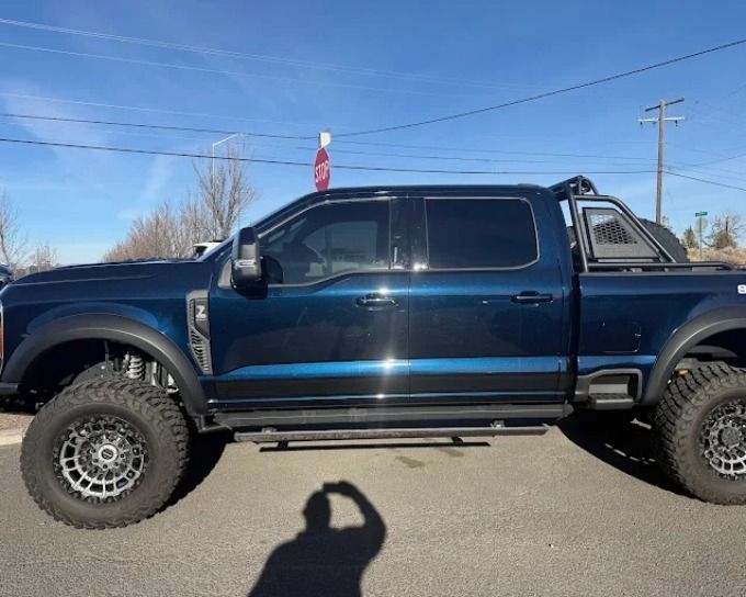 Blue lifted Ford truck with dark window tint darkness level, Redmond, Oregon