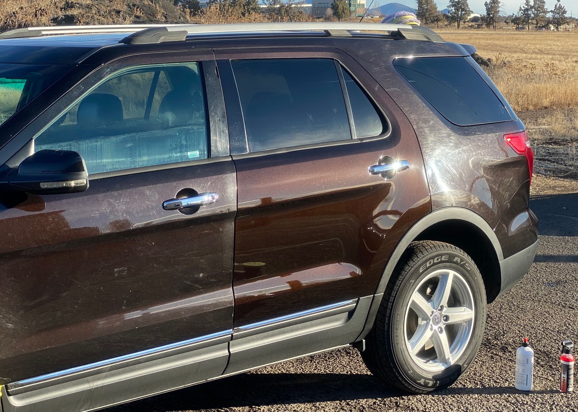 A brown suv is parked on the side of the road