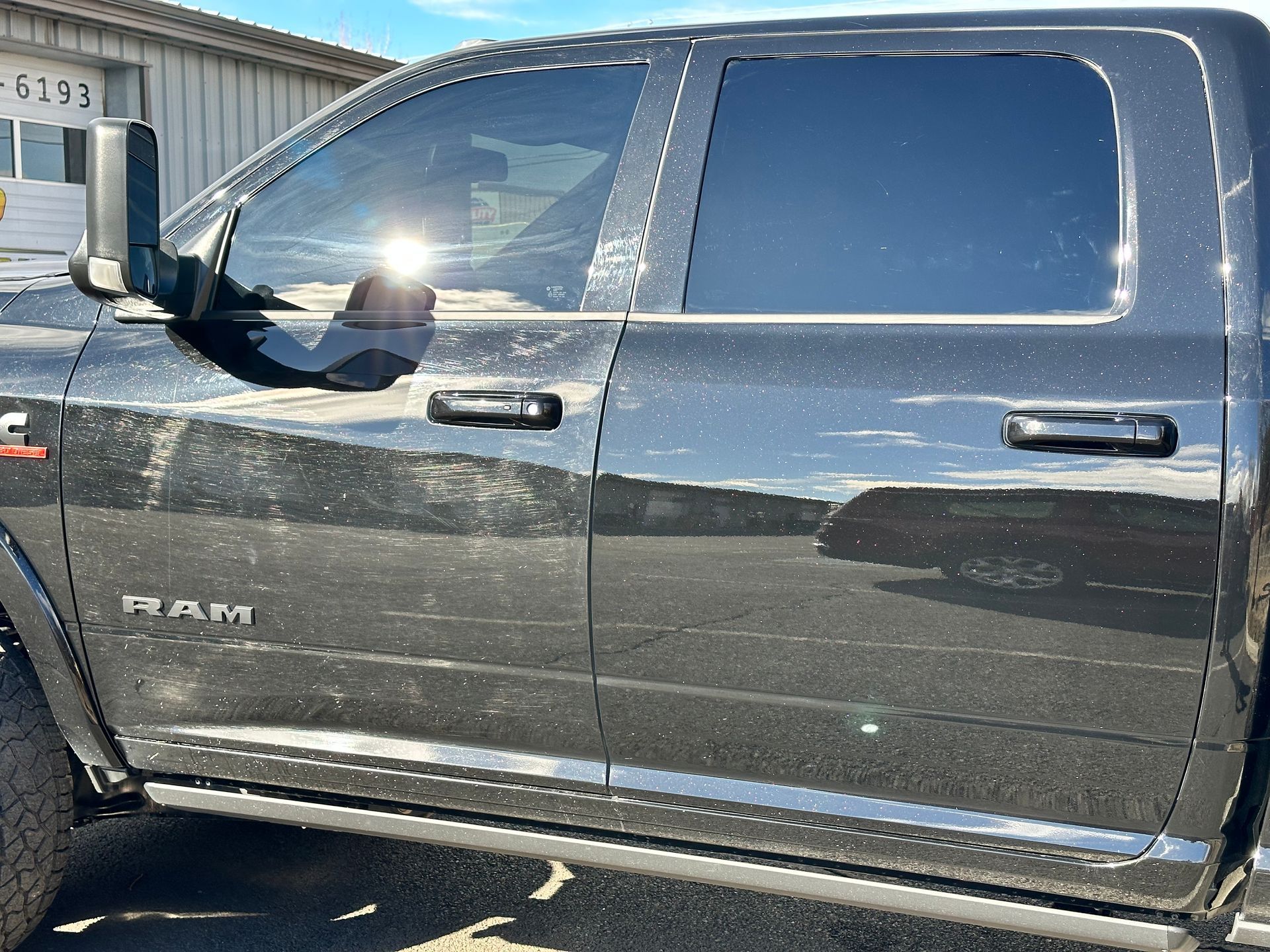 A black dodge ram truck is parked in front of a building