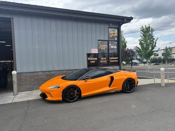 Orange McLaren GT sports car with sleek window tinting in Redmond, OR
