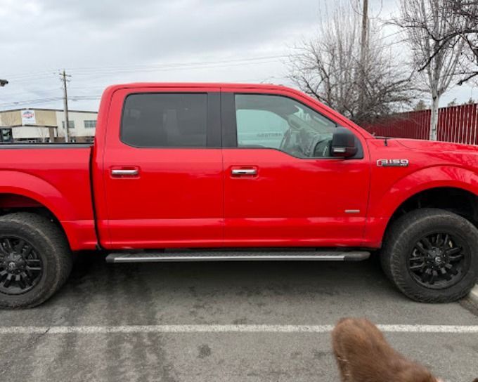 Red Ford F-150 pickup truck with sleek window tint in Redmond, Oregon