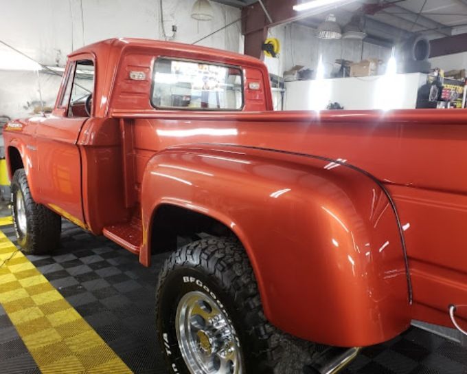 Restored classic orange pickup truck with a mirror finish from ceramic coating