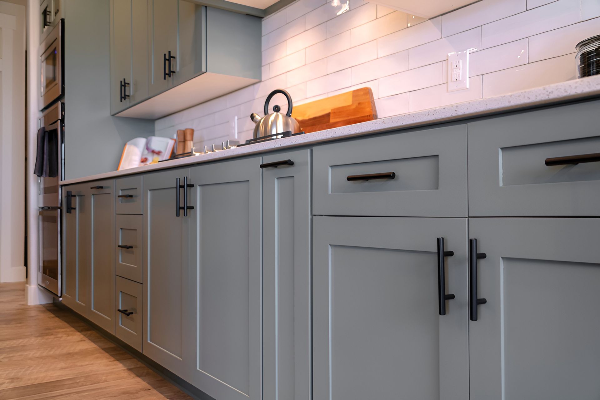 A Kitchen With Gray Cabinets and Black Handles and a Sink — Precision Kitchens & Cabinets in Tweed Heads, NSW