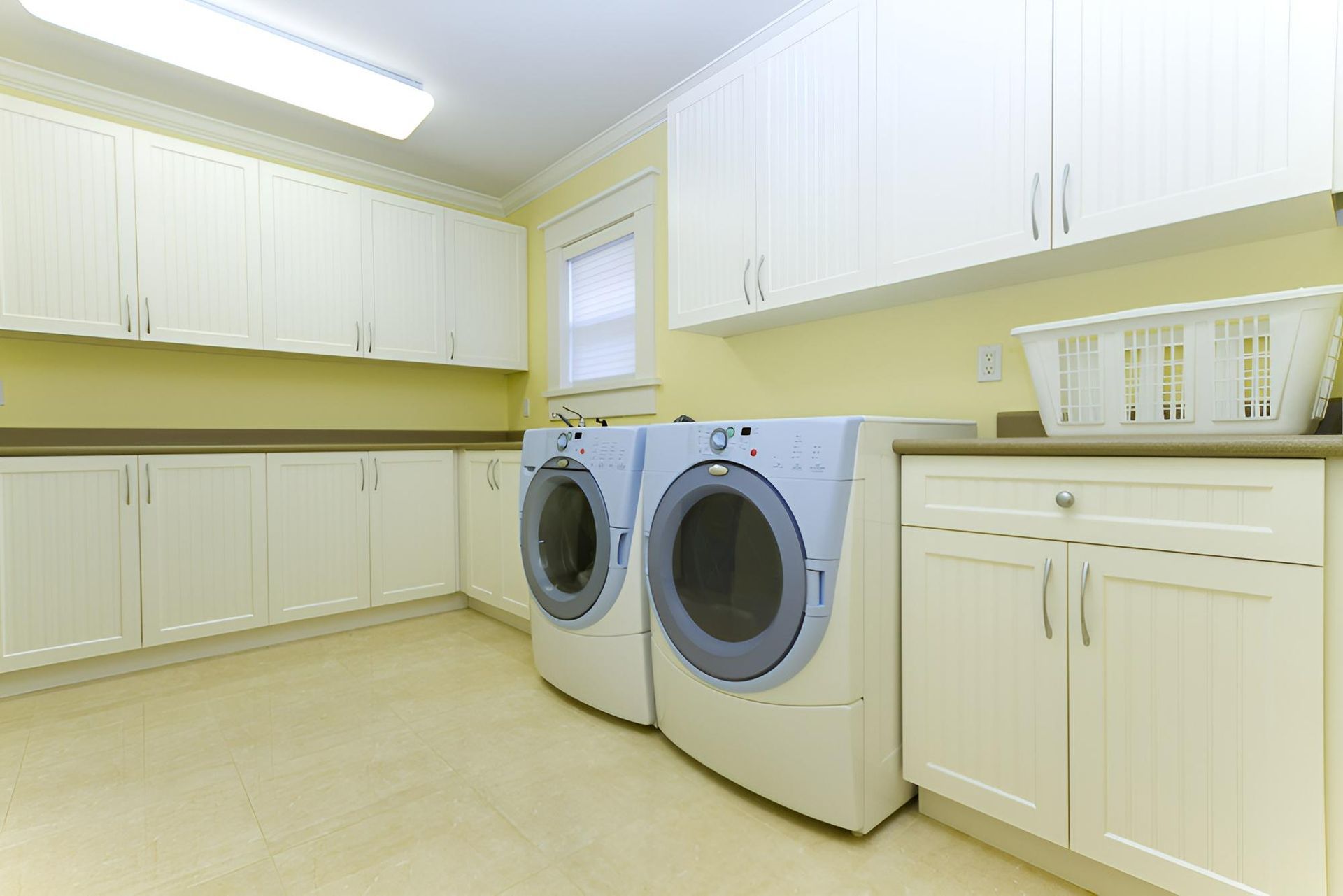 A Laundry Room With Two Washers and Two Dryers — Precision Kitchens & Cabinets in Ballina, NSW