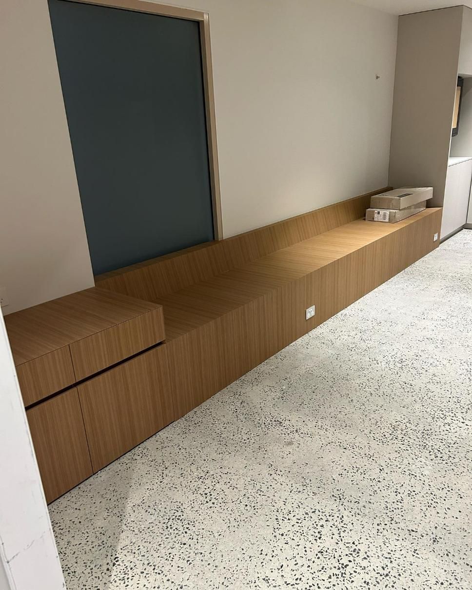 A Long Wooden Bench is Sitting in a Room Next to a Window — Precision Kitchens & Cabinets in Ballina, NSW