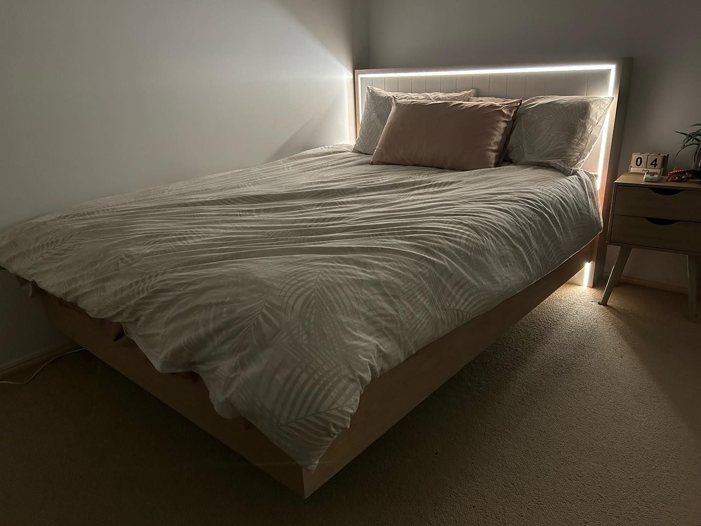 A Bed With a White Comforter and Pillows in a Bedroom — Precision Kitchens & Cabinets in Ballina, NSW