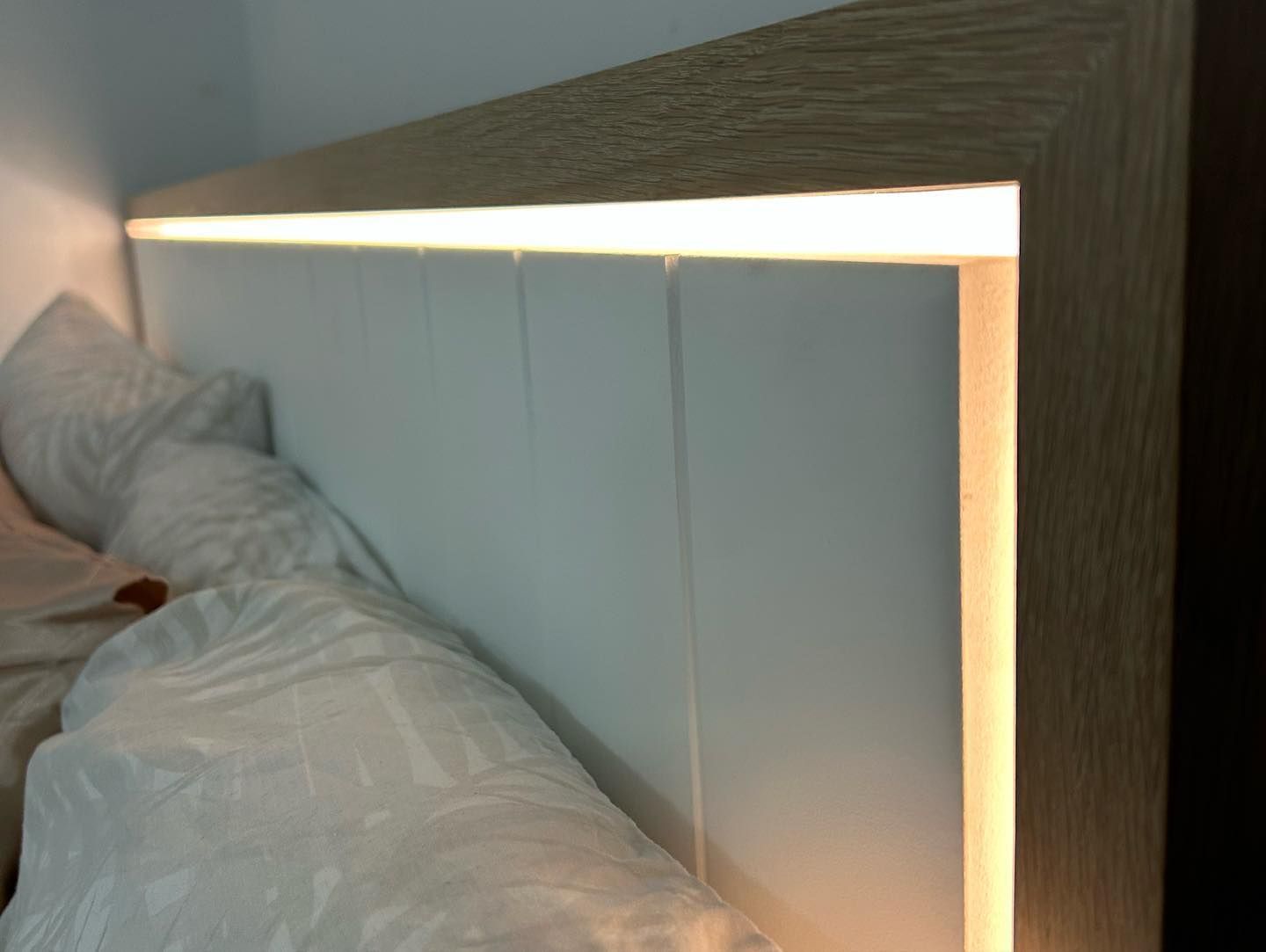 A Bed With a Wooden Headboard and a Light on It — Precision Kitchens & Cabinets in Ballina, NSW