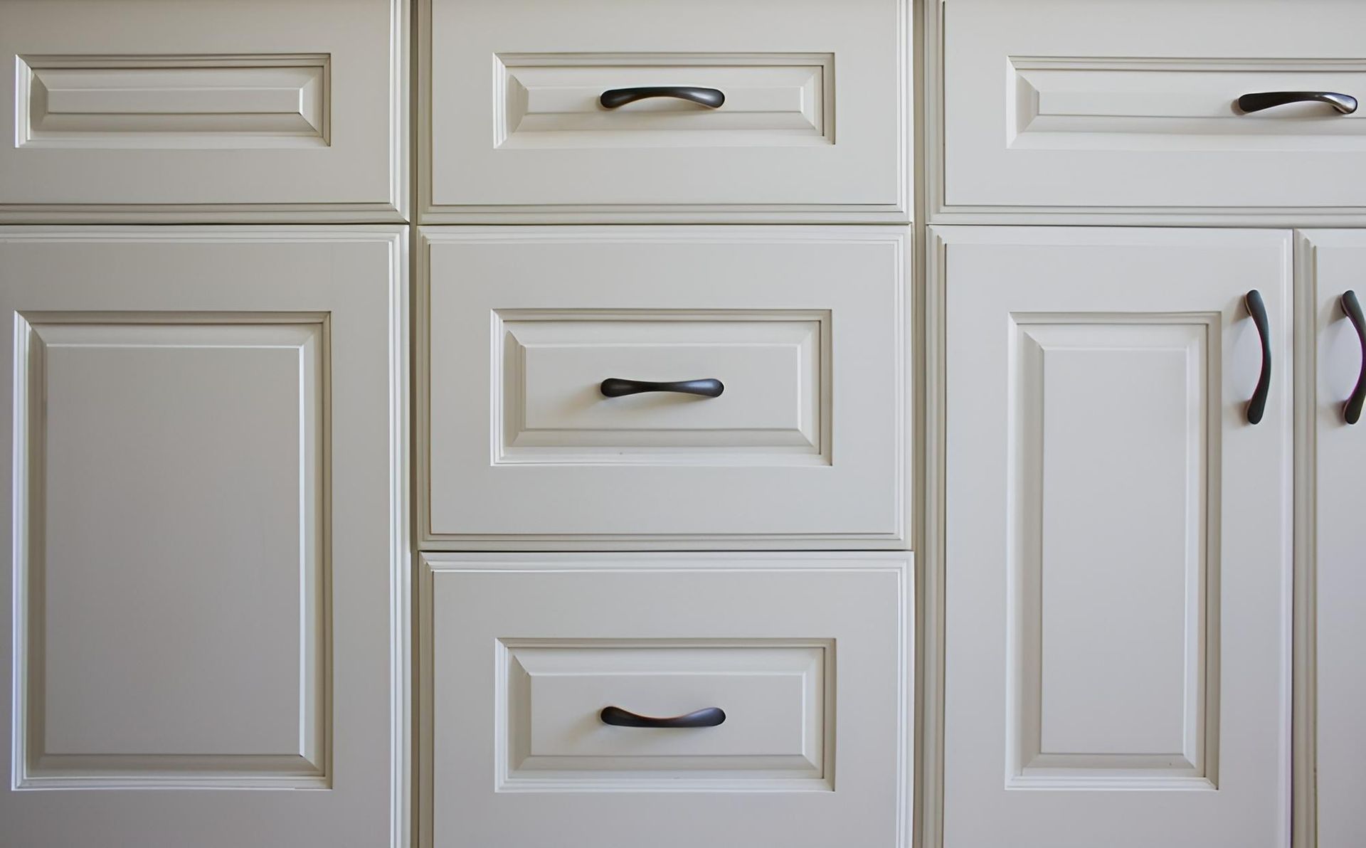 A Row of White Cabinets With Black Handles — Precision Kitchens & Cabinets in Yamba, NSW