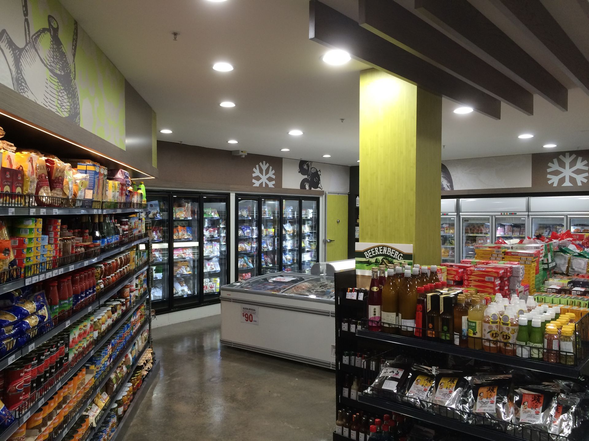 Convenience store aisle with snacks, freezers, and bright overhead lights