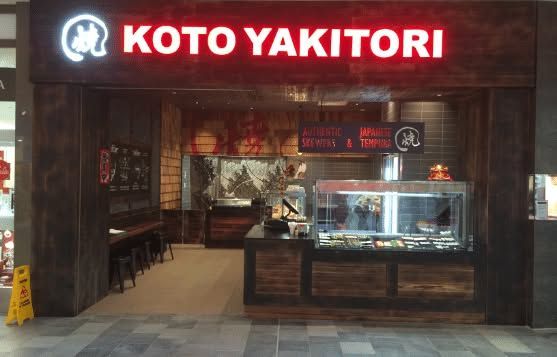 KOTO YAKITORI storefront with red illuminated sign and glass display case at the entrance