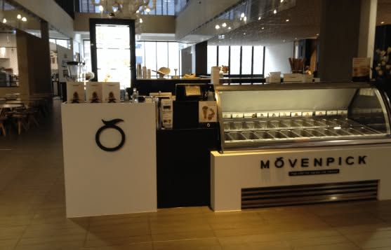 Mövenpick café counter with display cases and seating in a modern lobby