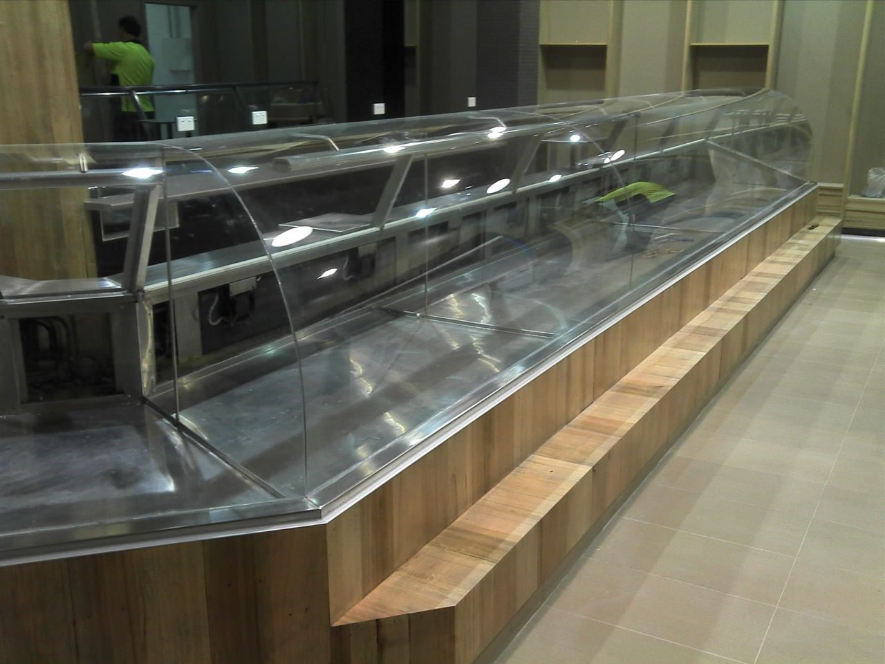 Glass-topped display case with wooden bench seating in a modern interior