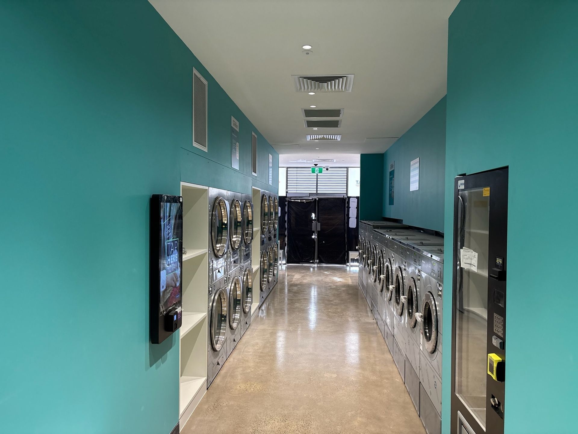 Bright hallway with turquoise walls and rows of metal lockers on both sides