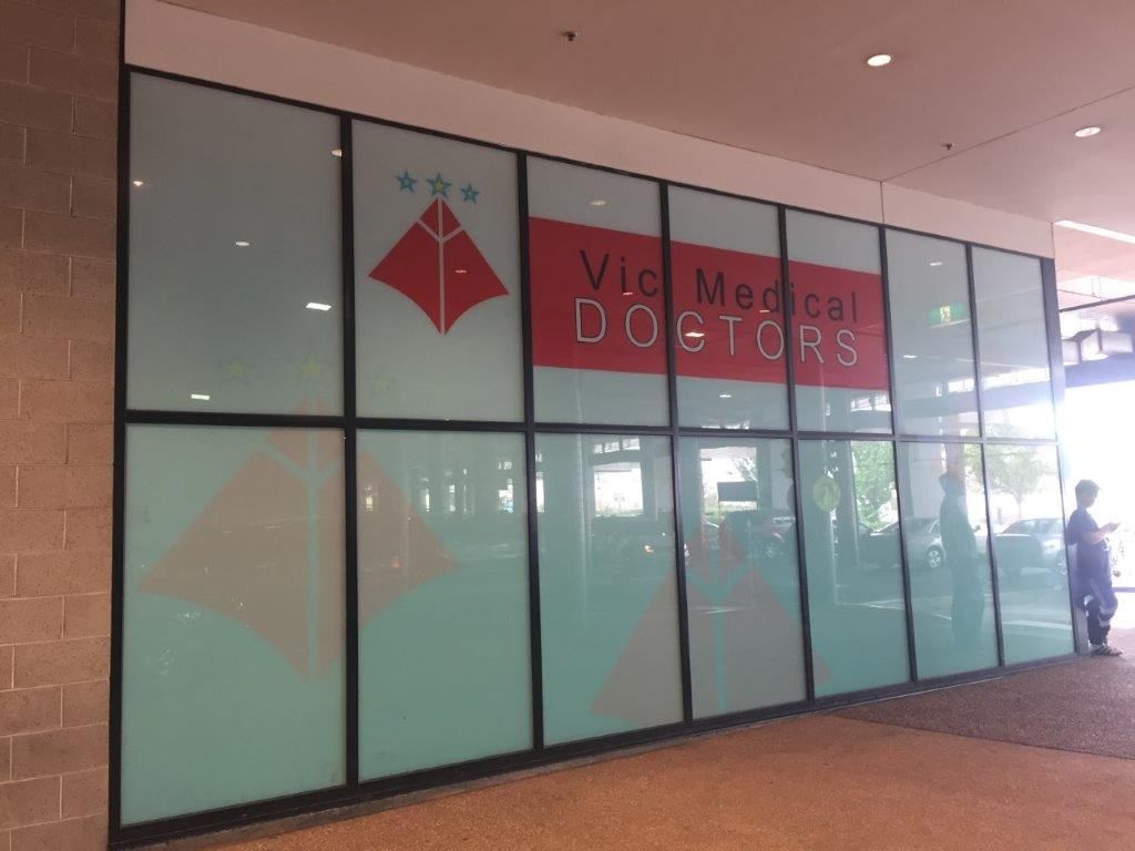 Veterinary clinic storefront with red sign and glass doors under a covered walkway