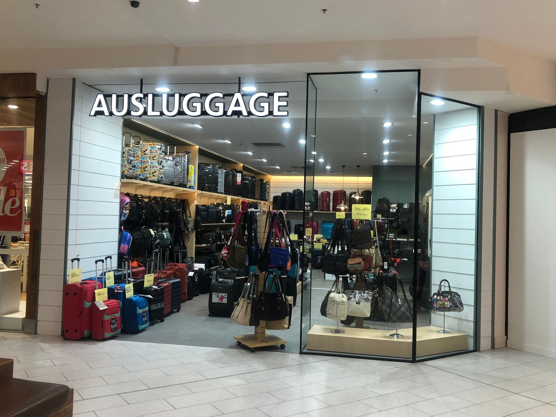 Luggage store storefront with suitcases, backpacks, and travel bags displayed inside