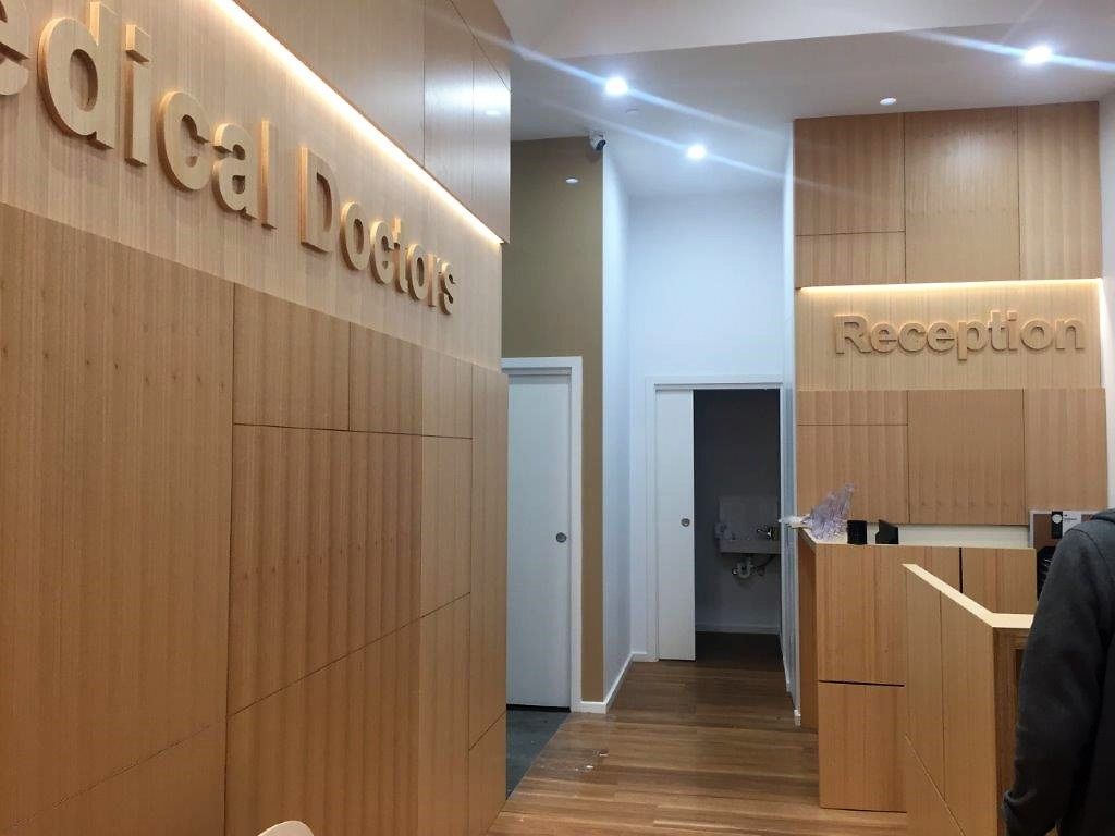 Clinic reception area with wood-paneled walls and a hallway leading to rooms.