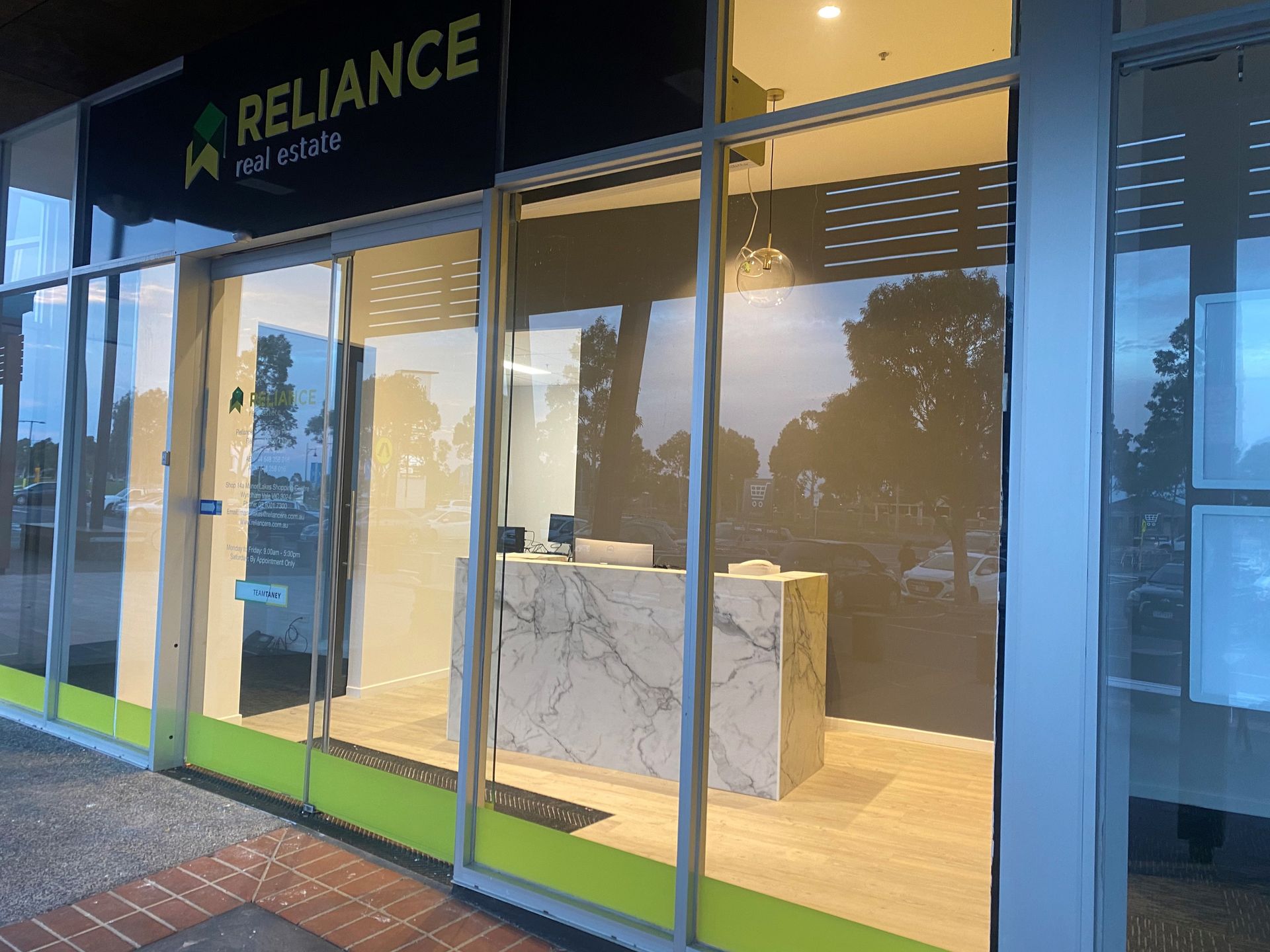 Glass-fronted Reliance store entrance with marble counter and warm interior lighting