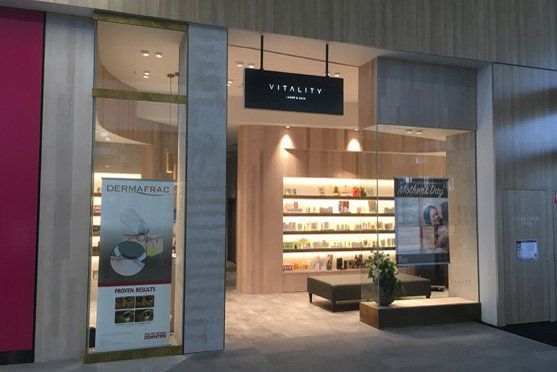 Modern boutique storefront with warm lighting, display shelves, and a central seating bench