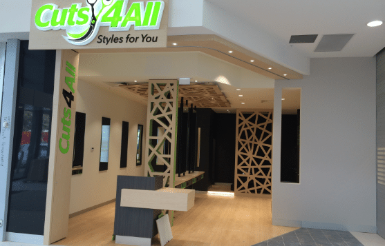 Cuts4All salon storefront with green sign, white walls, and a modern interior entrance