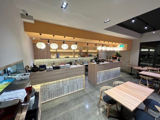 Modern café interior with pendant lights, counter seating, and wooden tables