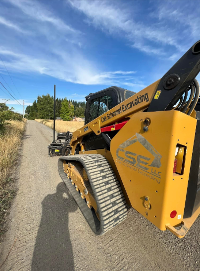 Yellow bulldozer pushing earth on a construction site; blue sky in the background.