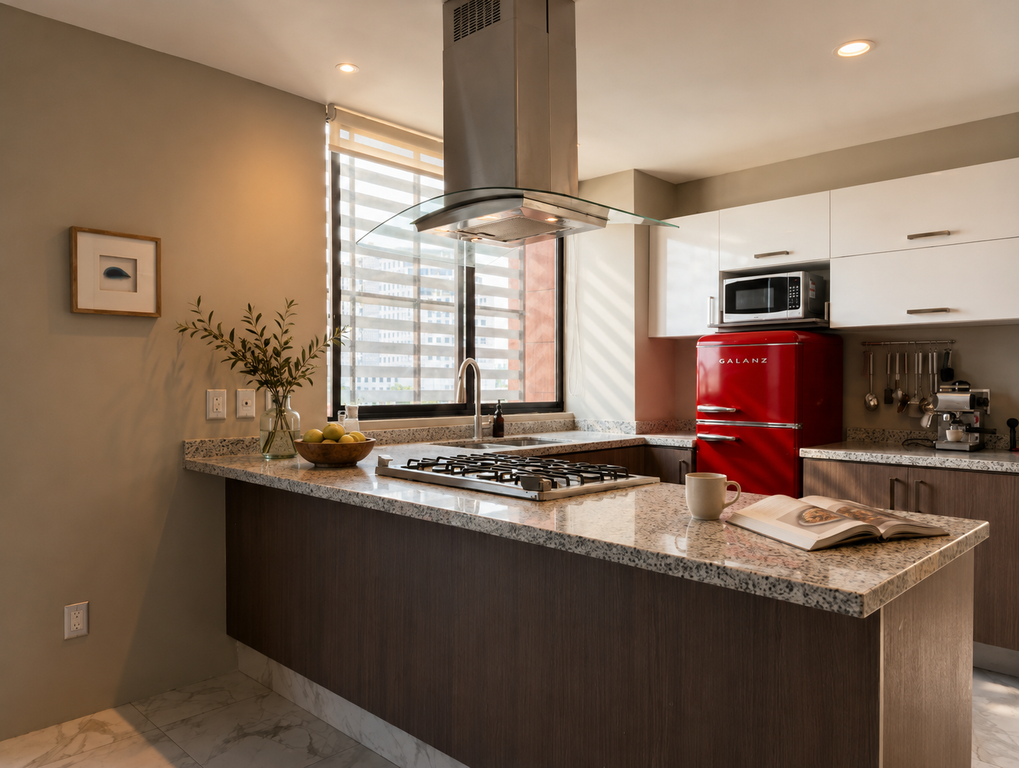 Modern kitchen with granite island, red refrigerator, stainless range hood, and window blinds