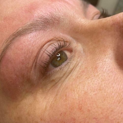 A close up of a woman 's eye with long eyelashes.