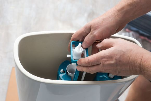 Hands placing blue and white devices into a white trash bin