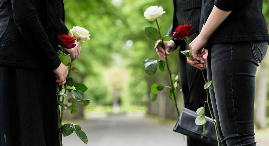 people standing in a line facing each other holding a rose