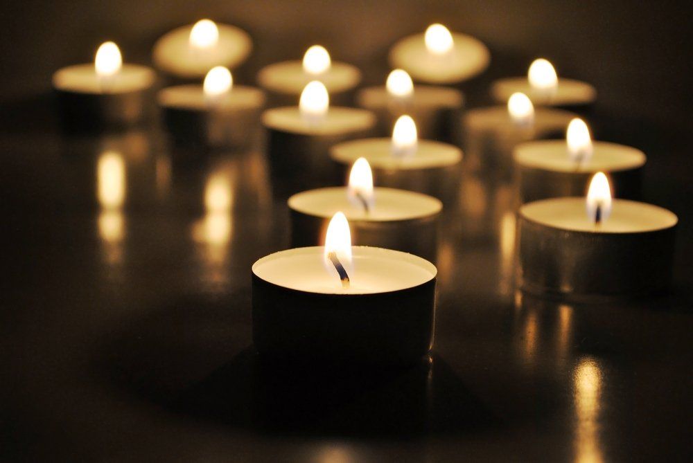Candele tealight accese che brillano in un ambiente buio e riflettente