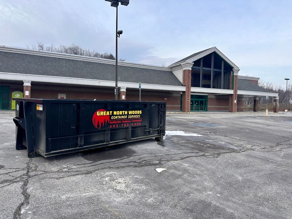 A commercial dumpster is parked in front of a large building in Conway, NH.