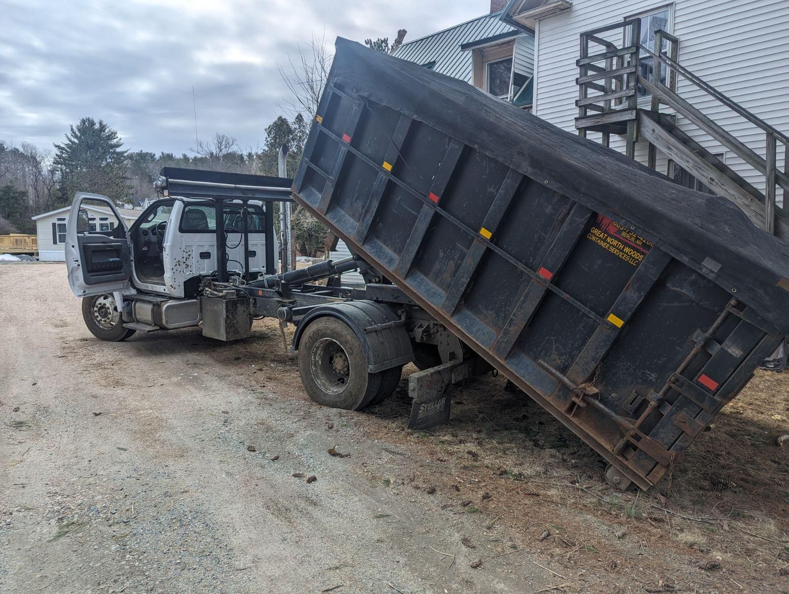 A roll off dumpster rental is being dropped off for delivery in Conway, NH. 