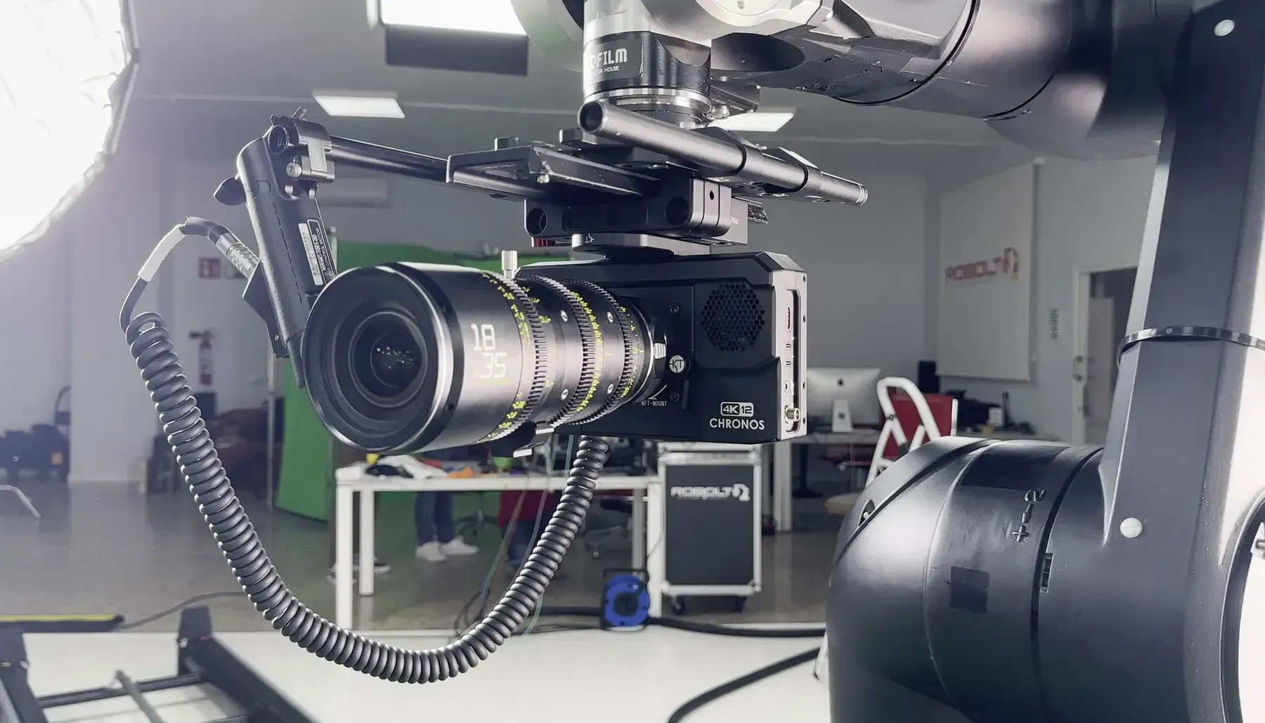 A camera is sitting on top of a robotic arm in a room.